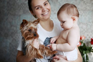 Güzel genç anne yorkshire köpek ve gülümseyerek yürümeye başlayan çocuk ile bir