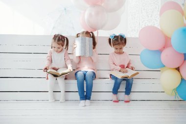 Mutlu üç çocuk kitapları ile oturan