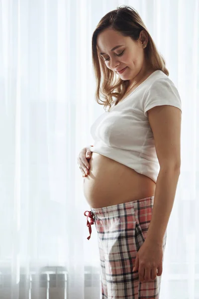 Imagem da mulher grávida zangada posando isolada sobre a parede cinzenta. Olhando para a câmera com os braços cruzados . — Fotografia de Stock