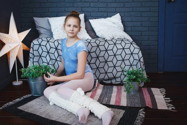 Beyaz külotlu mavi giysili bir genç kızı yere halıya oturur — Stok fotoğraf