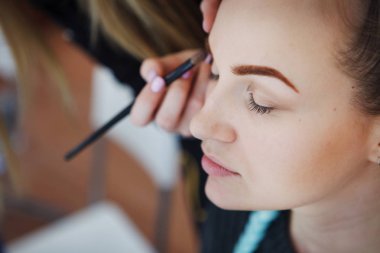 Güzel bir genç kız olun bir makyaj kozmetik bir fırça ile