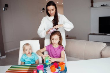 Anne çocuklarla oynuyor.