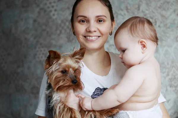 Hermosa madre joven con perro yorkshire y niño sonriendo un —  Fotos de Stock