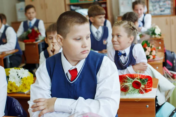 Красивый школьник за столом на празднике. Получает образование в начальной школе — стоковое фото