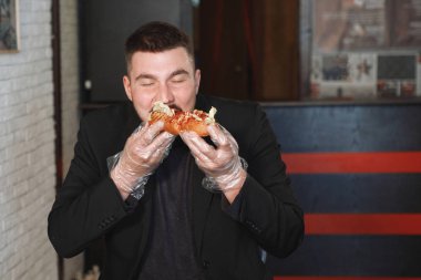 Adam hamburger yiyor.