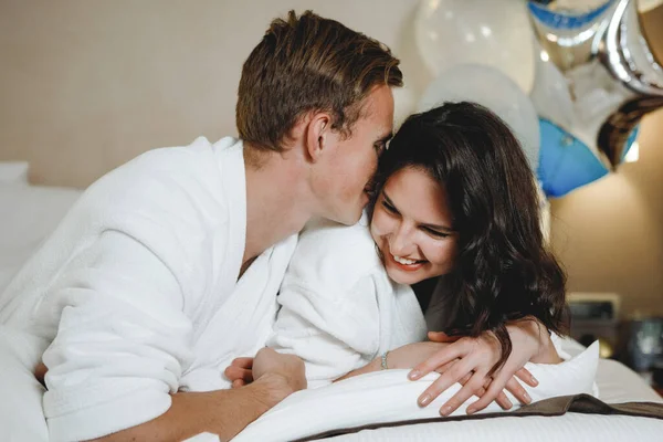 Casal alegre acordando e olhando um para o outro na cama — Fotografia de Stock