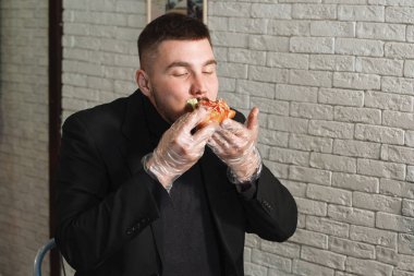 Adam hamburger yiyor.