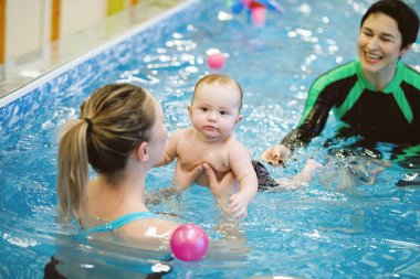 Kadın ve çocuk su havuzunda yüzerler..