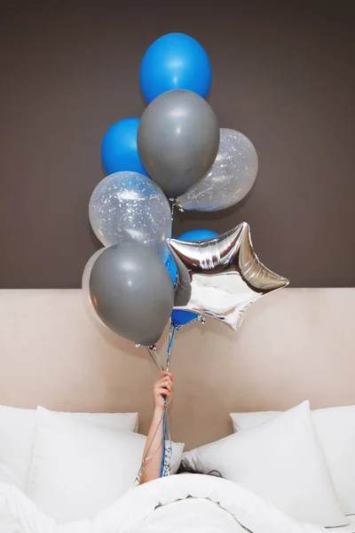 Giovane donna con palloncini si trova a letto . — Foto Stock