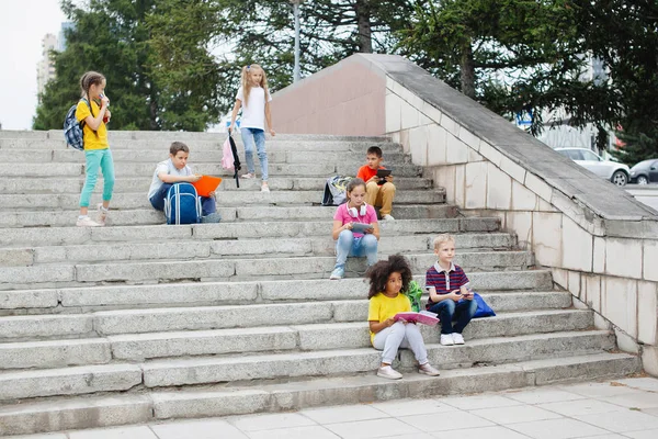 Grupp Skolbarn Olika Nationaliteter Färgglada Kläder Sitter Stentrappa Tonåringar Pratar — Stockfoto