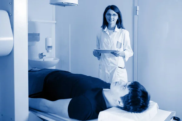 女性医師放射線技師は 医療室での手順のための患者を準備します — ストック写真
