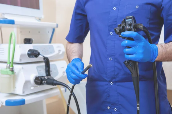 Gastroskopi, endoskopi. Doktor 'un elleri, karın boşluğu araştırması için ameliyat aparatına hazırdır: fibrogastroduodenoskopi, mide incelemesi.