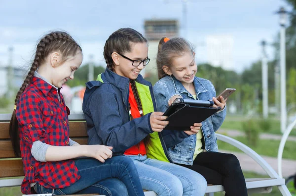 Trois Adolescentes Avec Smartphone Tablette Assises Sur Banc Dans Parc — Photo