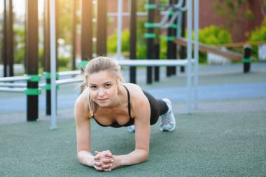 Sıcak bir sonbahar gününde kadın fitness modeli eğitimi ve müzik dinlemek. Spor yaşam tarzı.