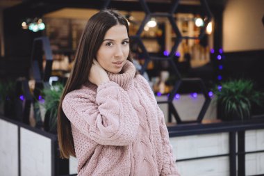 Kameraya poz veren genç ve güzel bir kadın. Bulanık arkaplanda cafe portresi.