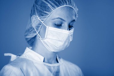 Ameliyat sırasında şapkalı ve maskeli hemşire