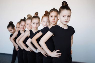 Siyah taytlı ergen kızlar dans, bale ya da ritmik jimnastik dersinde sıraya girer..