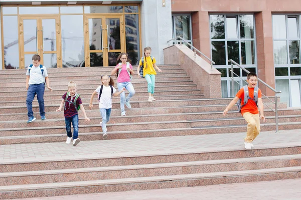 Группа Школьников Рюкзаками Выбегает Школы После Урока — стоковое фото