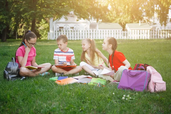 Quatro Crianças Sentam Gramado Lêem Desenham Parque Cidade — Fotografia de Stock