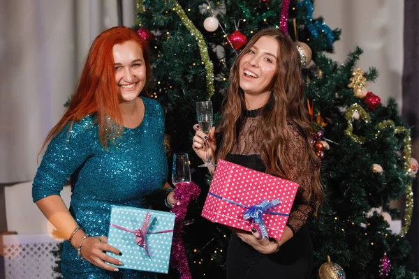 Twee Vriendinnen Geven Elkaar Cadeaudozen Bij Een Kerstboom — Stockfoto