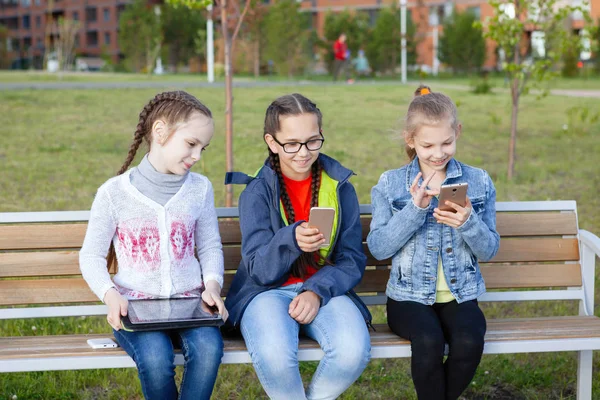 Tres Adolescentes Con Teléfono Inteligente Sientan Banco Parque Verano Ciudad — Foto de Stock