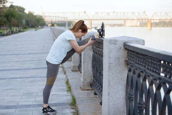 穿着运动服的女人在城市公园里做伸展体操 — 图库照片