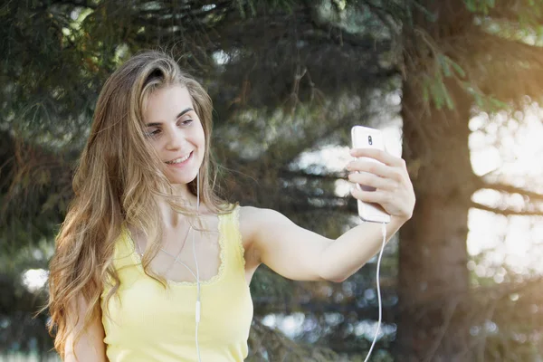 Woman Makes Selfie Smartphone Yellow Shirt Jeans Bench City Park — Stock Photo, Image