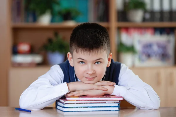 Tiener Schooljongen Zittend Aan Een Tafel Met Een Stapel Boeken — Stockfoto