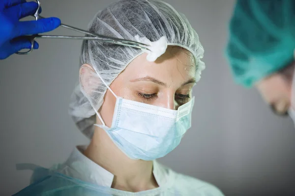 Ameliyat Sırasında Alnından Terli Bezle Şapkalı Hemşireye Maskeli Hemşireye Kadar — Stok fotoğraf