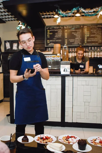 Waiter takes a customer order for a tablet with a stylus in a cafe or restaurant.