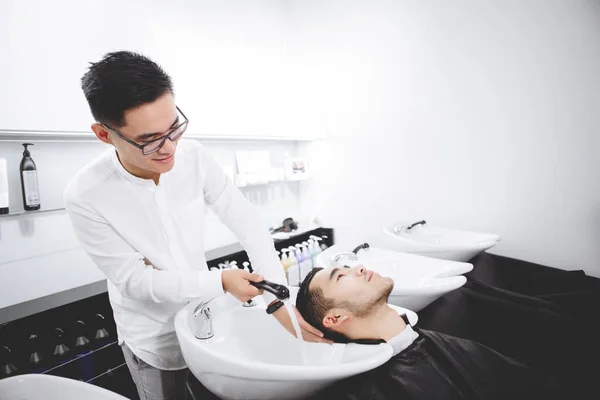 Young Guy Hairdresser Washes Man Head Cutting His Hair — Stock Photo, Image