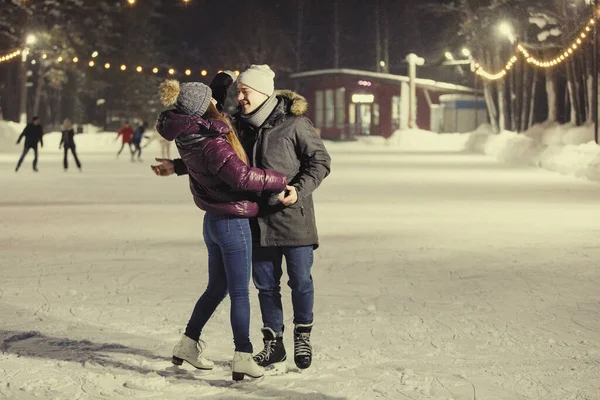 Geliefden Man Vrouw Schaatsen Knuffel Avond Ijsbaan Winter Nachtlampjes Bloemenslingers — Stockfoto