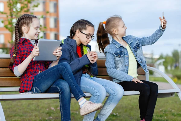 Trois Adolescentes Avec Smartphone Tablette Assises Sur Banc Dans Parc — Photo