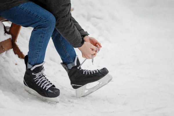 Jongeman Lace Skates Zitten Een Bank Buurt Van Ijsbaan Winter — Stockfoto