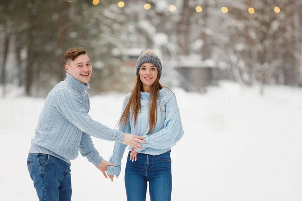 冬の公園で抱き合うカップルを屋外で愛する 暖かい服 ニット帽 雪のドリフト ぼやけた背景 — ストック写真