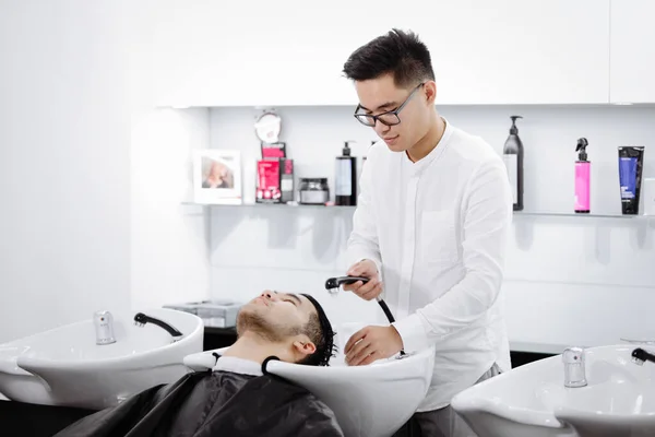 Young Guy Hairdresser Washes Man Head Cutting His Hair — Stock Photo, Image