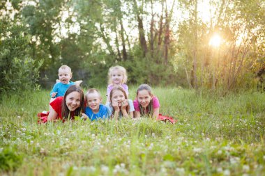 Bir grup genç çimlerin üzerinde uzanıp eğleniyor..