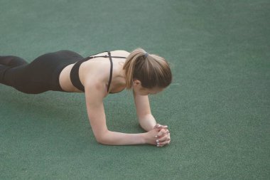 Spor salonundaki kadın jimnastik standı Yazın şehir parkında yapay yeşil çimenler üzerinde