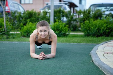 Spor salonundaki kadın jimnastik standı Yazın şehir parkında yapay yeşil çimenler üzerinde