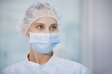 Klinikte başlık ve maske takan cerrahi hemşire. Yakın plan portre. Sağlık, ameliyat..