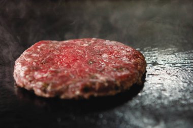 Doğranmış et pirzolası ve elektrikli ocakta dumanla kızartılıyor..