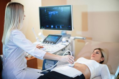 Kadın doktor hastanın ultrason çalışmasını yürütüyor..