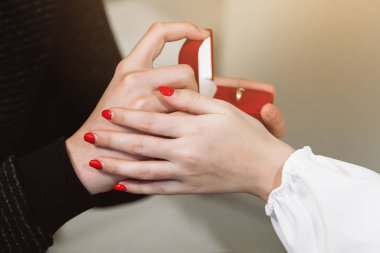 Adam kız arkadaşına evlenme teklif ediyor. Aşıkların elleri yakın plan.