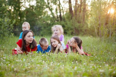 Bir grup genç çimlerin üzerinde uzanıp eğleniyor..