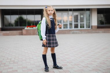 Ekose etekli sırt çantalı liseli kız okulda çalışmaya hazır..