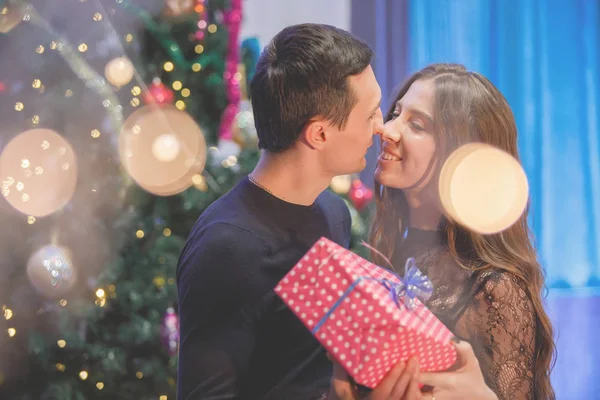 Man Vrouw Met Een Geschenk Buurt Van Een Versierde Kerstboom — Stockfoto