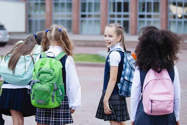Pupils in uniform and with backpacks go to school.