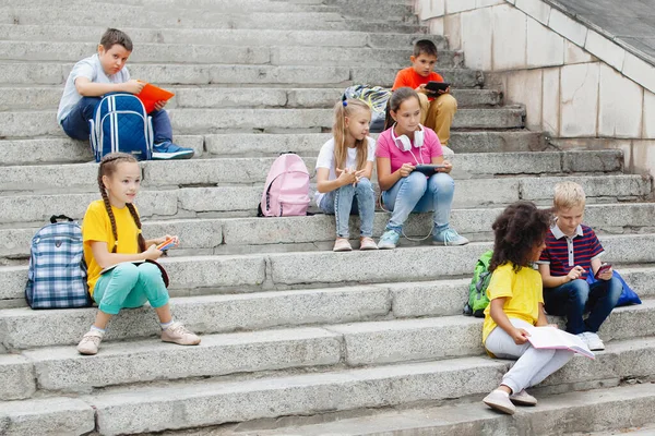 Ομάδα Μαθητών Διαφορετικών Εθνικοτήτων Πολύχρωμα Ρούχα Που Κάθονται Πέτρινα Σκαλοπάτια — Φωτογραφία Αρχείου