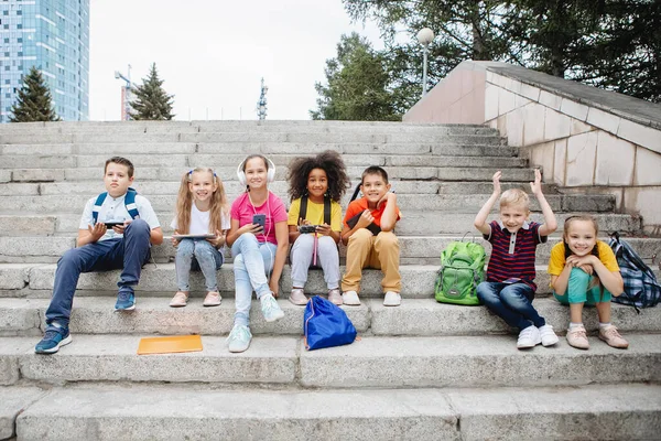 Ομάδα Μαθητών Πολύχρωμα Ρούχα Κάθονται Στα Σκαλιά Και Ψάχνουν Για — Φωτογραφία Αρχείου