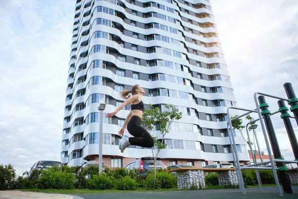 Donna Fitness Che Salta Sullo Sfondo Grattacielo Parco Cittadino Estate — Foto Stock